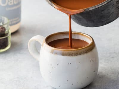 Close up of pot of hot chocolated being poured into a mug.