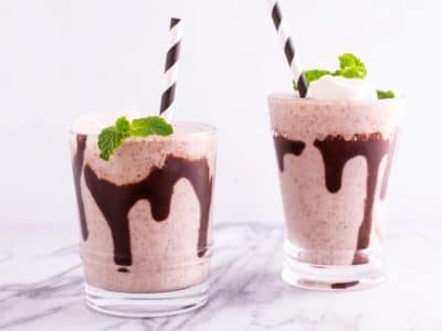 Two Glasses of Mint Chip Vegan Milkshake with Chocolate Drizzle