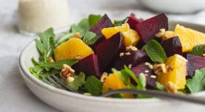 plate of mixed salad green topped with gold and red beets.