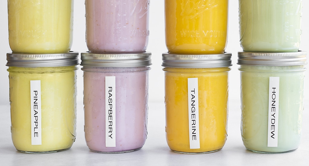 Mason jars filled with different flavors of smoothies.