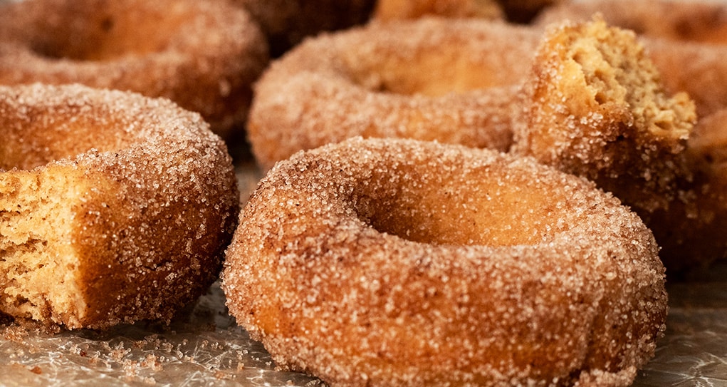 Close up of cinnamon sugar dusted apple cider donuts.